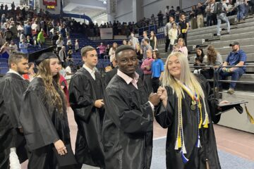 Grads walking out fist bumping